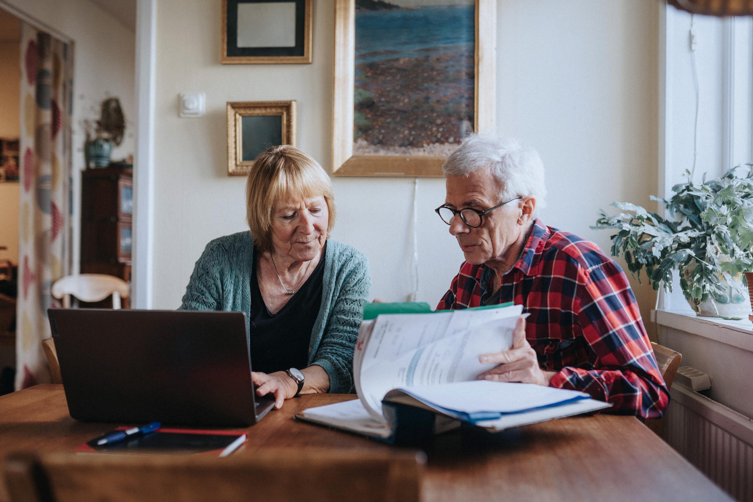 Äldre par som sitter framför en laptop