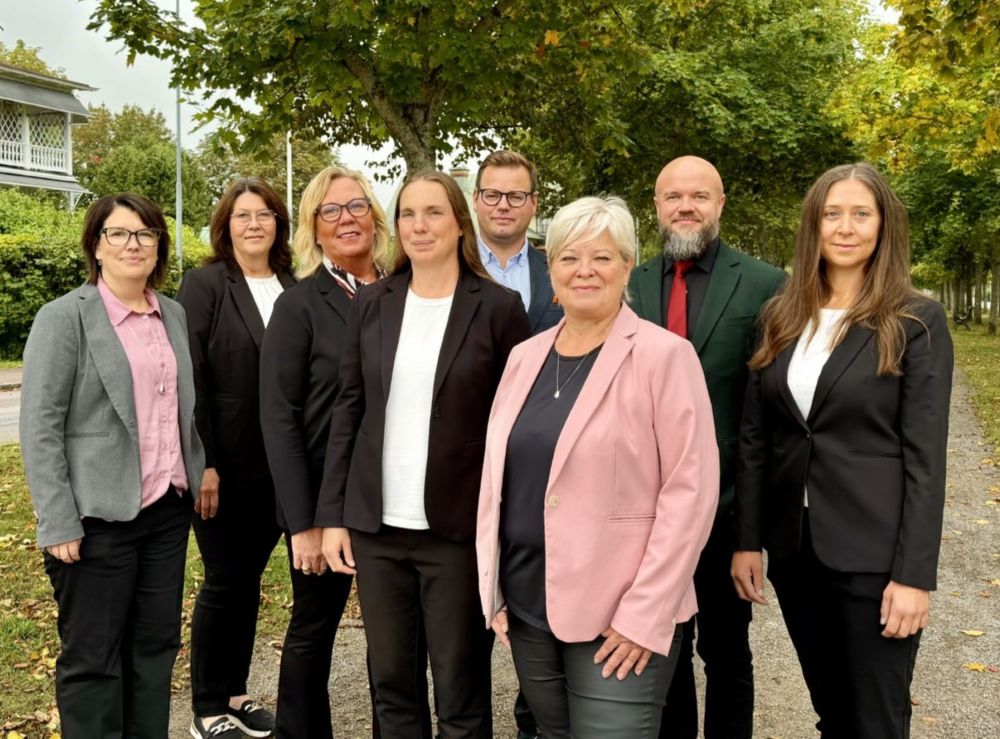 En grupp människor står i en allé 