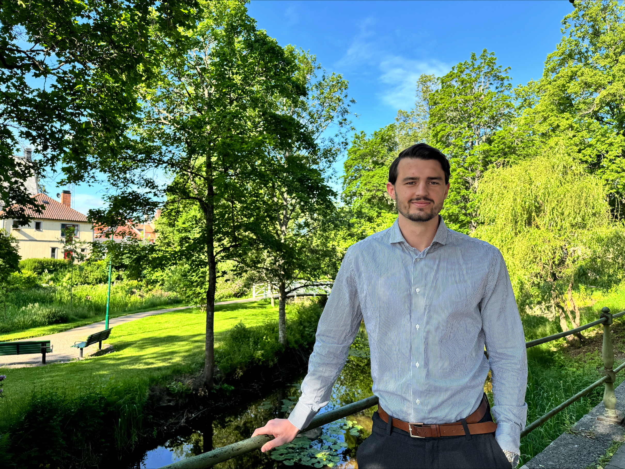 En man står lutad mot ett broräcke. 